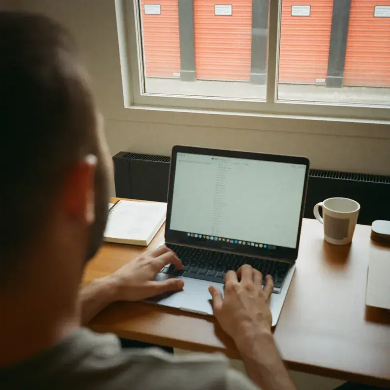 Scott Wilder, founder of Stitch Storage, working at a laptop (photo shows hands and desk, face not shown)